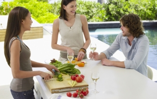 A happy group of three using an outdoor kitchen